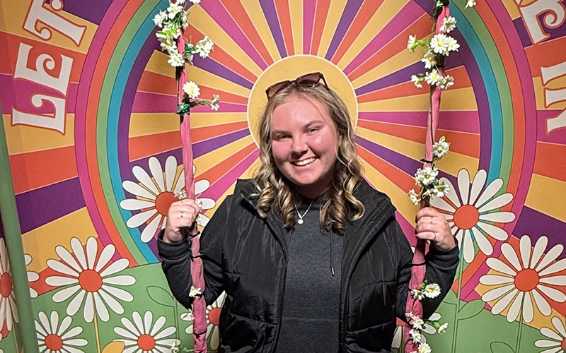  Marissa McPherson in front of flowers and rainbow Backdrop