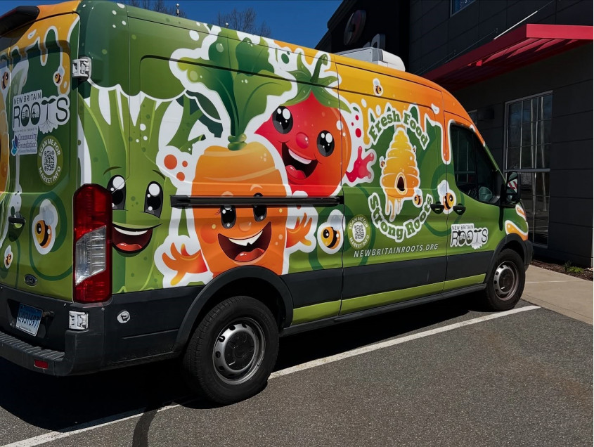 View of the New Britain ROOTS mobile market truck. Images of painted vegetables are shown on the truck.