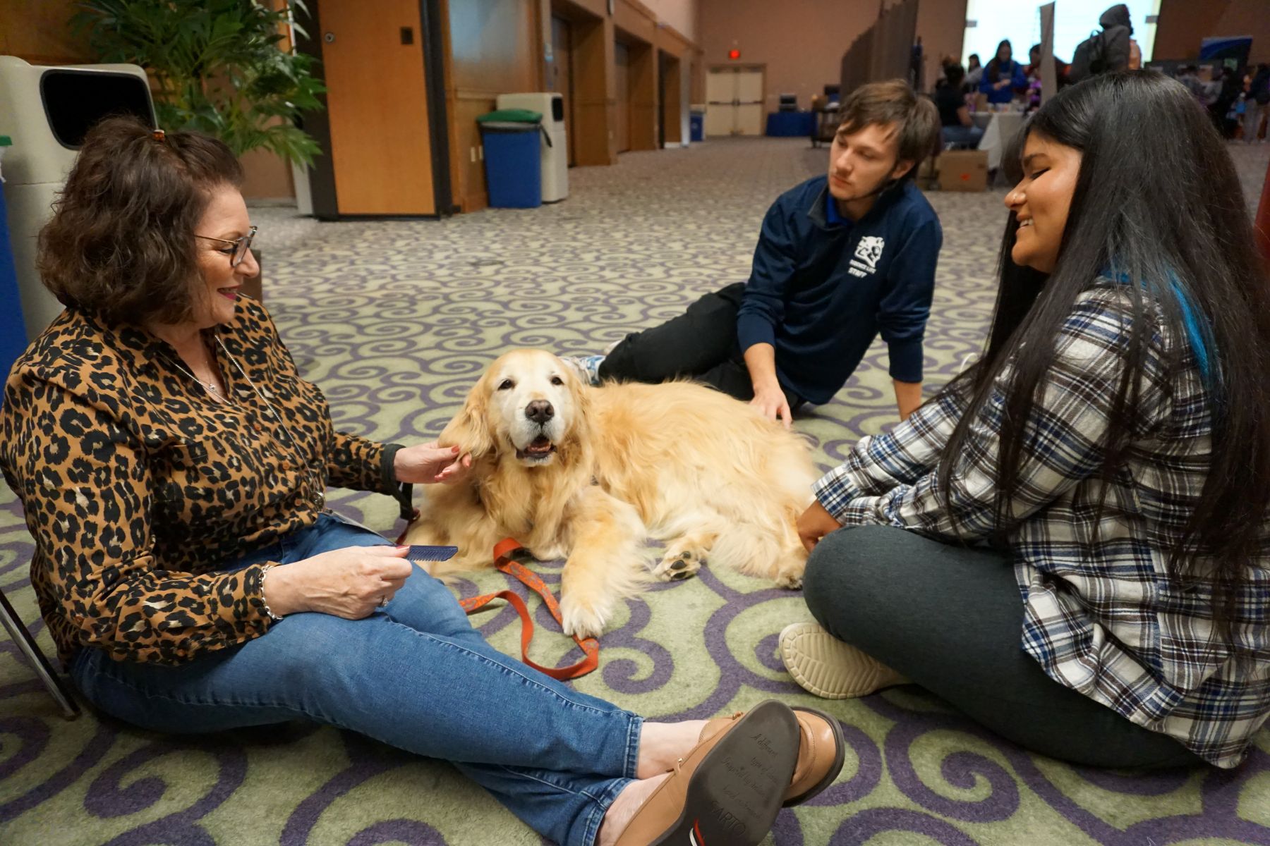 Central students and faculty sit with a therapy Golden Retriever.