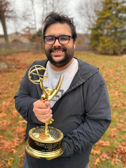 Toledo Nils holding an Emmy outside
