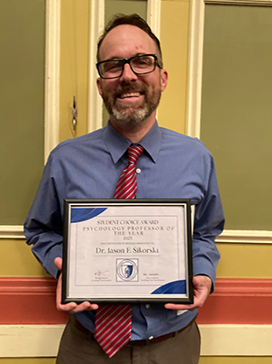 DR Jason Sikorski holding the 2025 Student Choice Award Psychology Professor of The Year