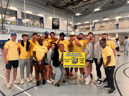 Students in yellow holding Dean's Cup sign