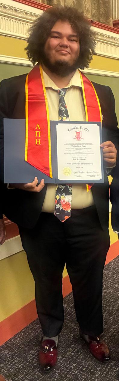 Jayden Oyola holding Lambda Pi Eta certificate