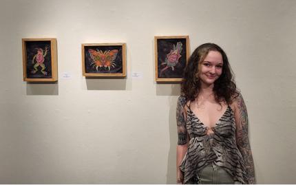 Art & Design student standing in front of art paintings