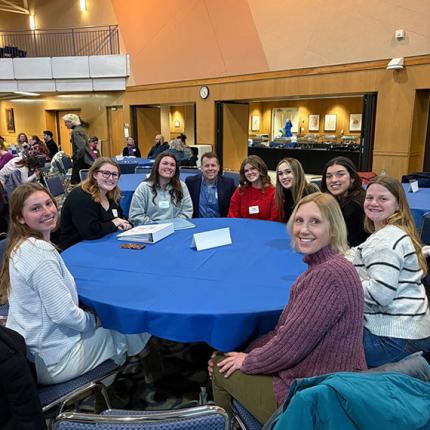 Students and staff sitting around table