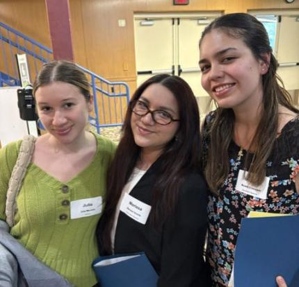 Students taking photo with blue folders