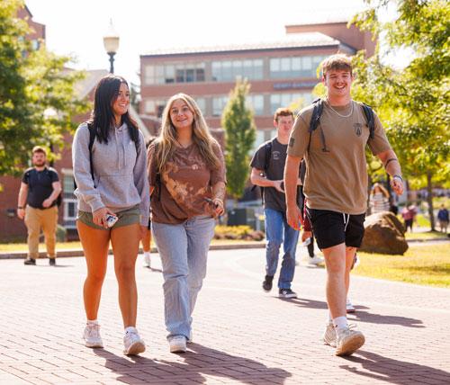 5 students walking outside on a sunny day