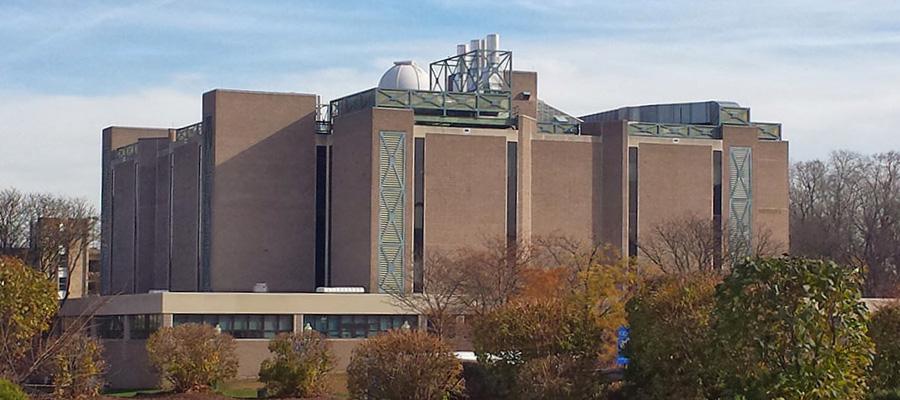 Copernicus Hall is a square building with large aluminum ventilation stacks on the roof 