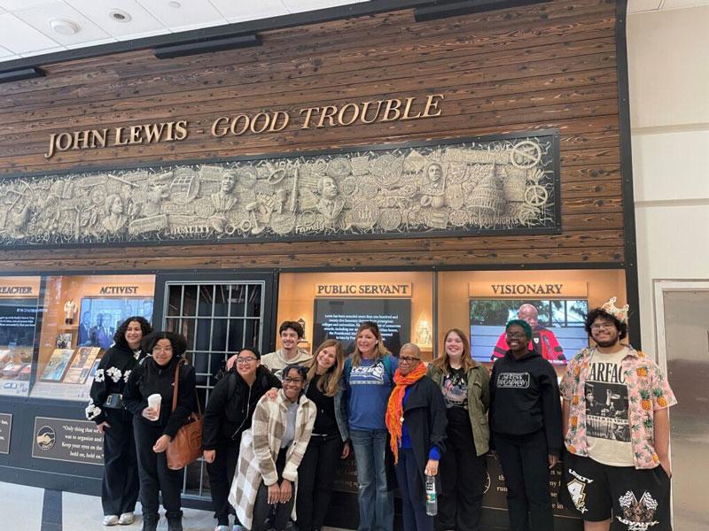 Students under sign that reads "John Lewis - Good Trouble"