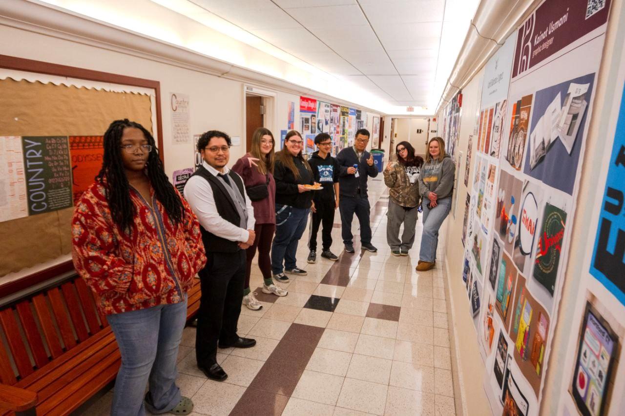 Students, joined by Professor Wujun Wang and Administrator Kevin Rivera, share their portfolios with family and friends during a recent showcase.