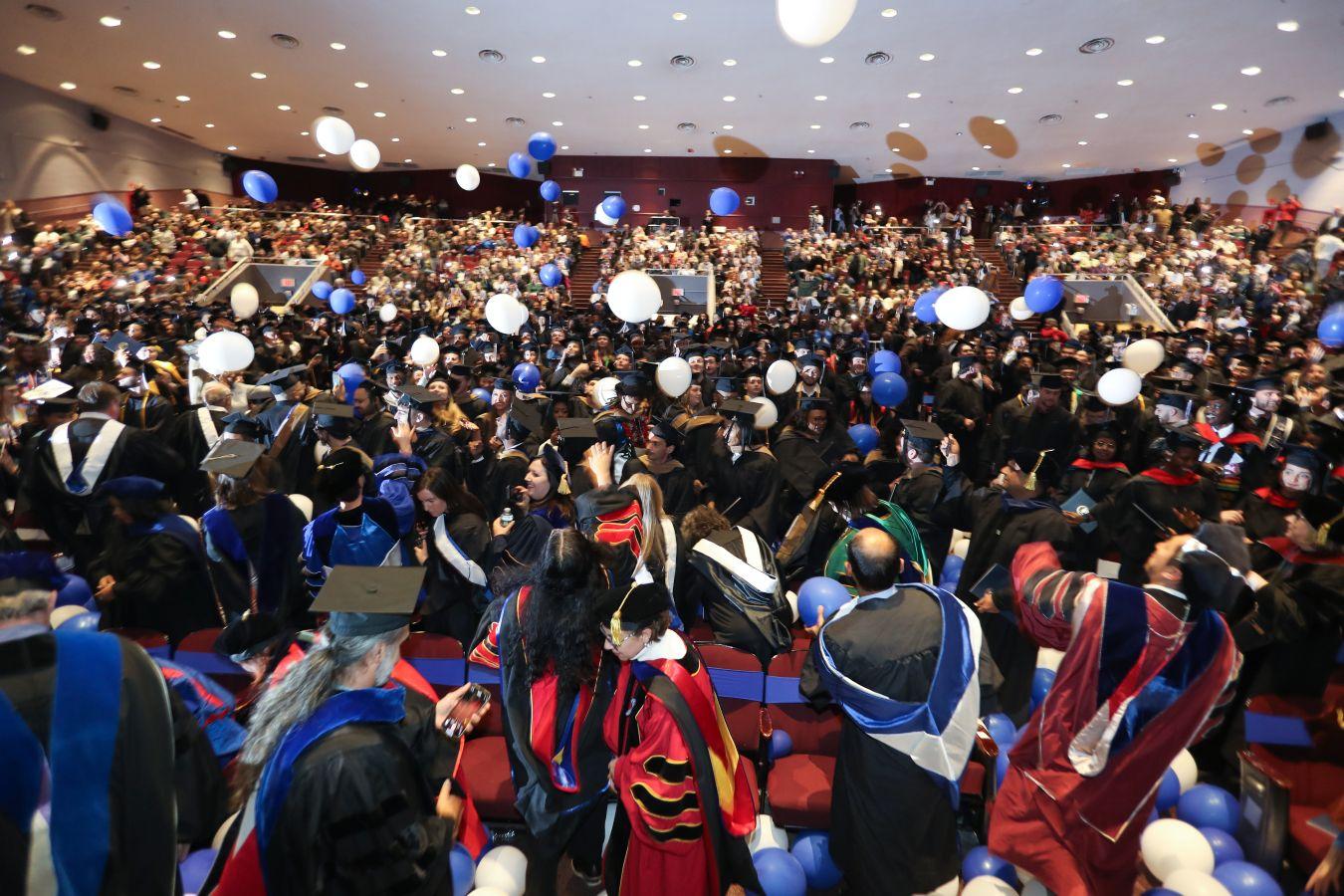 Blue and white balloons fall at the close of the December commencement ceremony at Welte Hall.