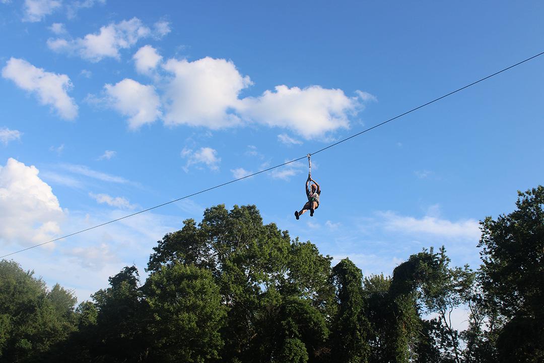 A person zip-lining over trees