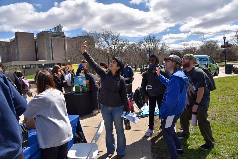 Student taking selfie in crowd outside copernicus hall