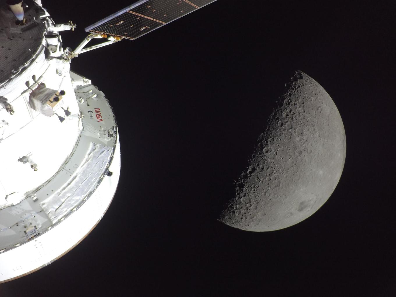 NASA’s Orion spacecraft is seen in the foreground, lit up by the Sun. A first quarter Moon is visible behind it, with sunlight coming from the right. Near the bottom right edge of the Moon, Orientale basin stands out with a black patch of ancient lava in its center. Orientale is a 600-mile-wide impact crater that straddles the near and far sides of the Moon and is ringed by mountains. (Image courtesy of NASA)