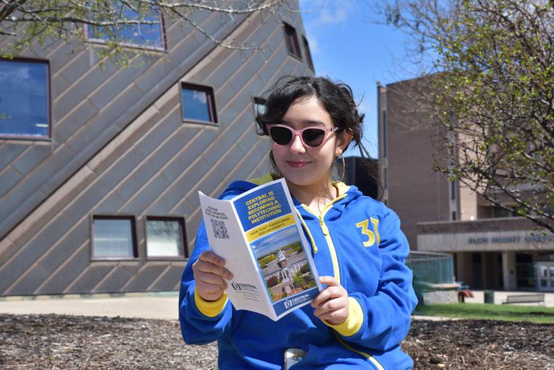 Female Student reading polytech flyer