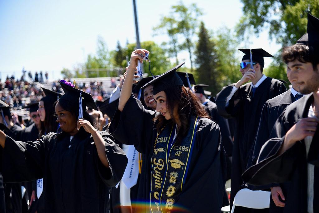 Graduates prepare to move their tassels to the other side of their academic caps