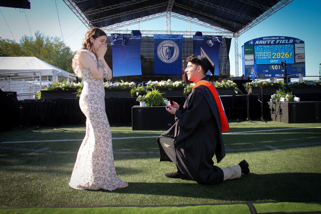 Graduate Joel Villalta-Corcino proposes to his girlfriend, Caitlyn Vicenzi, on the football field.