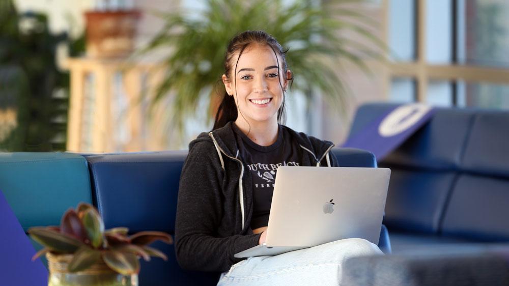 Student sitting inside on computer
