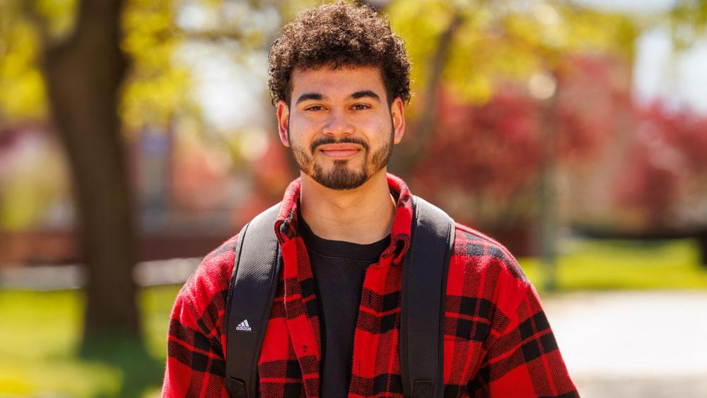 Student outside in fall with backpack