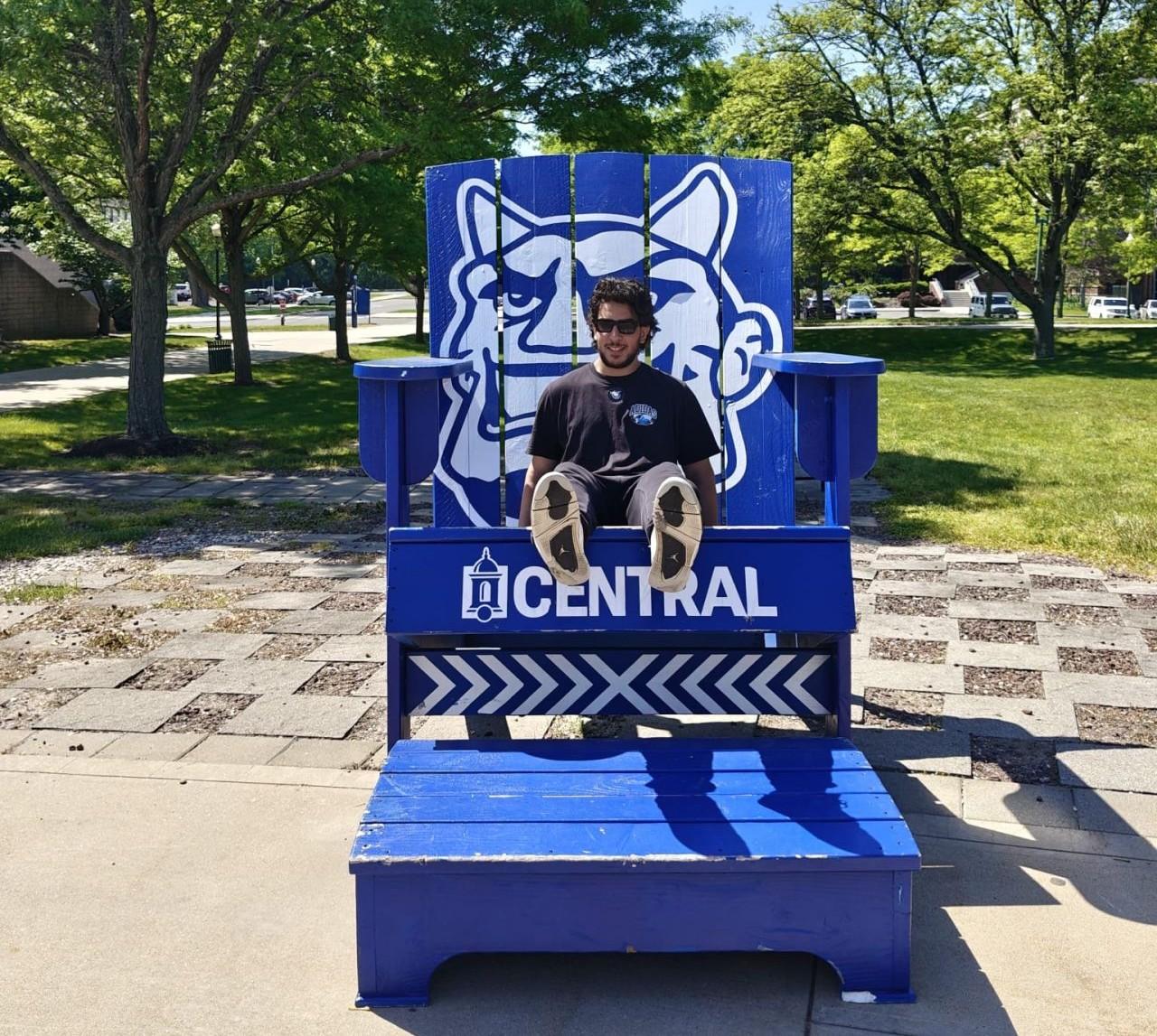 Exchange student Zakaria Butt settles in on the Central campus. He is shown here in the big blue chair outside the Student Center.