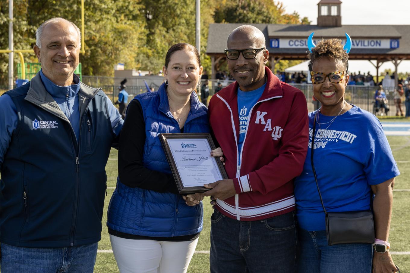 Central COO Sal Cintorino, Interim President Kimberly Kostelis, Larry Hall, and Persephone Hall are shown here on the football field at Central.