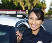 Female police officer smiling in front of patrol car