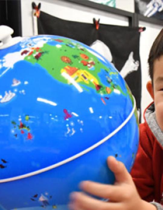 Small Child Holding Globe