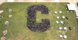 Drone photo of students in the shape of a C on Vance lawn.