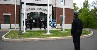 CCSU Police officers observe National Police Week on May 11. They are shown outside of the police department saluting a memorial wreath.