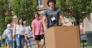 A Central student moves a box on a handtruck during a move-in event