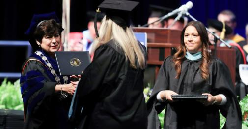 President Toro shakes hands with a graduate.