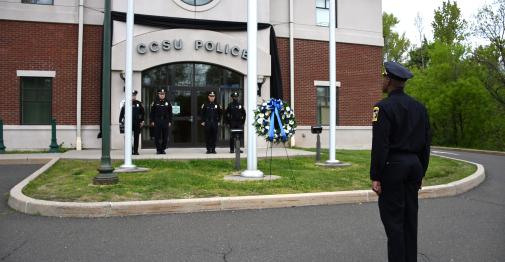 CCSU Police officers observe National Police Week on May 11. They are shown outside of the police department saluting a memorial wreath.