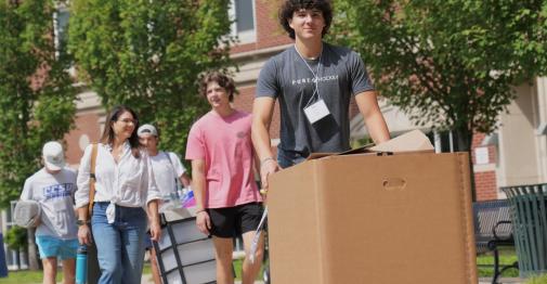 A Central student moves a box on a handtruck during a move-in event