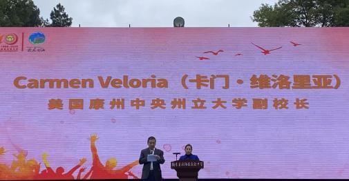 Dr. Carmen Veloria delivers remarks at the 40th anniversary celebration of the Ouyang Yu Experimental Middle School. Dr. Xudong Jia (left) translated her remarks into Chinese.