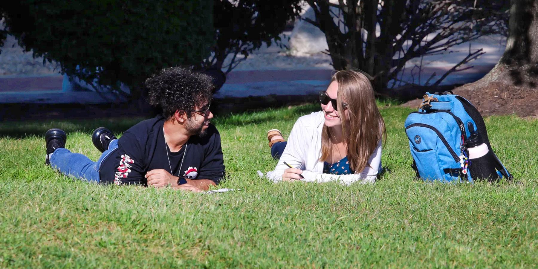 students laying in grass