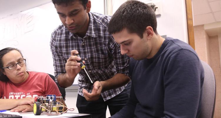 three students working on robotics project