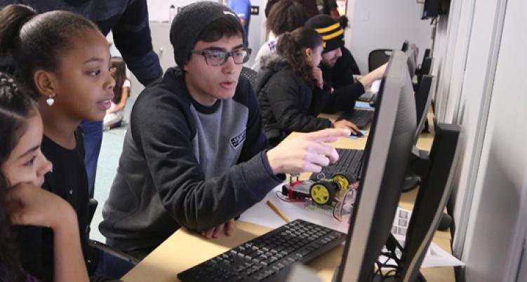 three students looking at computer