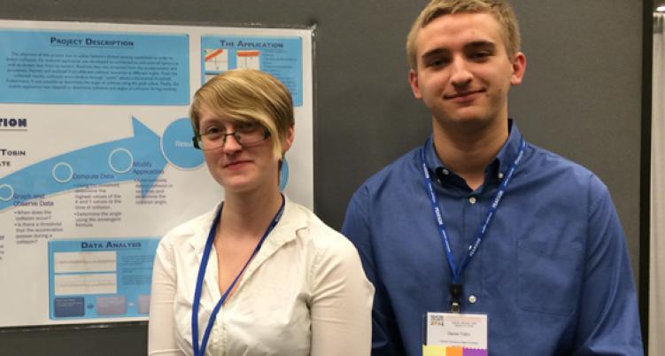 two students posed with presentation poster