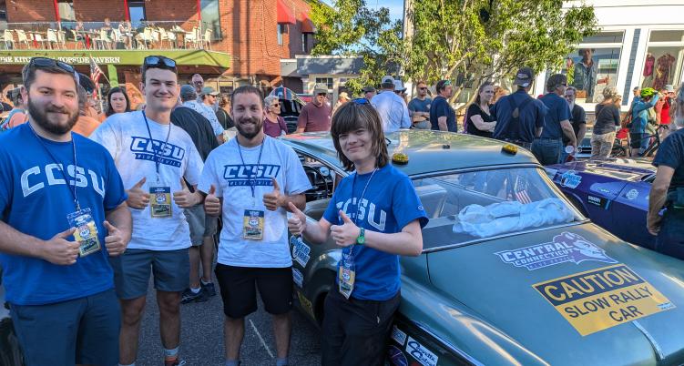 Students standing in front of a car