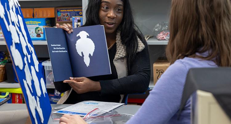 Staff reading book to student