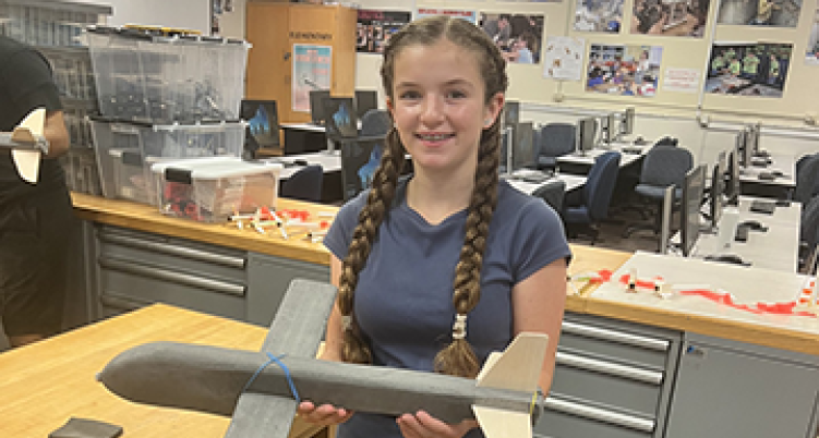 central student holding a model airplane