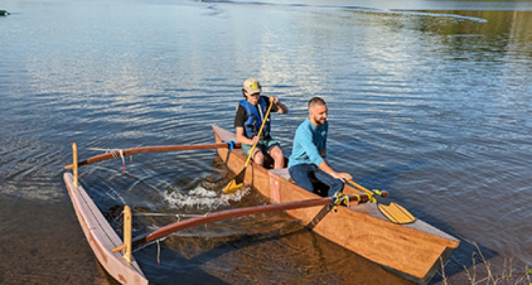 two people riding a canoe on the river edge