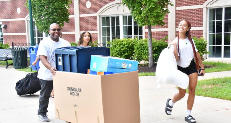 Students moving in with large boxes