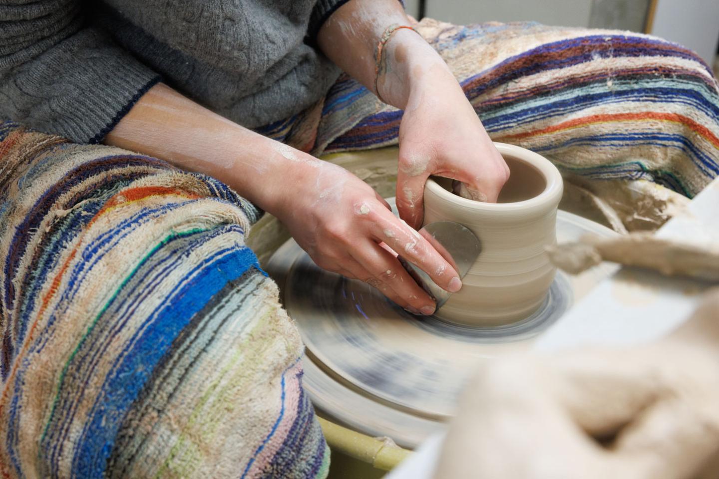 student doing pottery