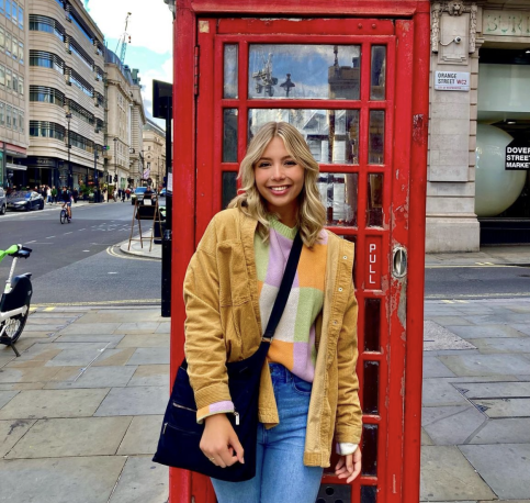 Blonde woman in front of London phone booth