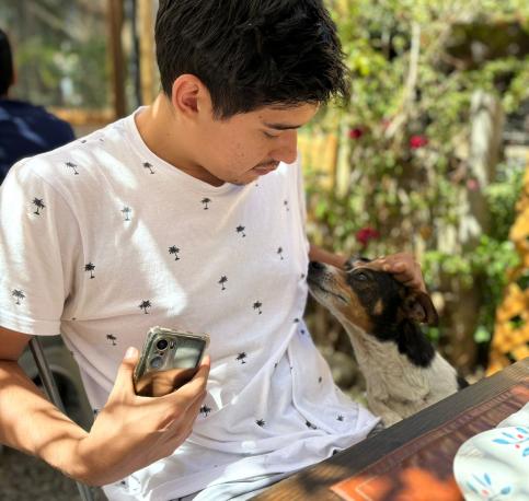 Photo of Benjamin petting a dog 