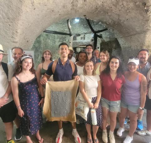 Students standing in a cavern with a cloth 